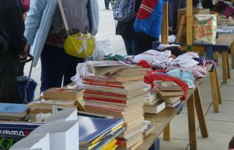 Gegenstände, bspw. Bücher, Vasen, Kleidung, an einem Stand des Geben- und Nehmen-Markts