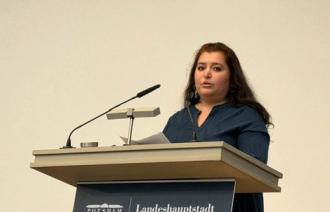 Eine Frau steht hinter einem Pult.