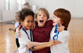 Drei Jungen in einer Turnhalle, die zusammen spielen.