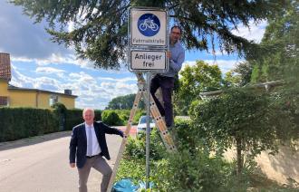 Bernd Rubelt (links) und Torsten von Einem (rechts auf einer Leiter stehend) an der neuen Fahrradzone.