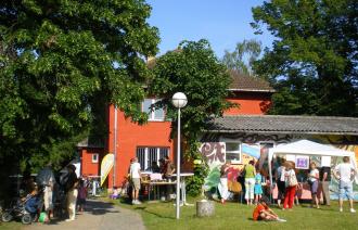 Das Groß Glienicker Begegnungshaus bei einem Fest, an dem viele Menschen vor dem Haus sind.