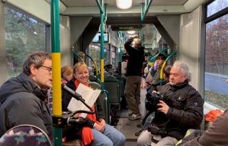 Personen in der Straßenbahn lesen im Vorleseexpress.