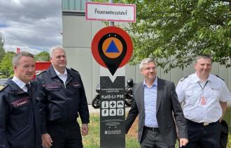 Oberbürgermeister Mike Schubert und drei weitere Männer stehen neben einem Katastrophenschutz-Leuchtturm.