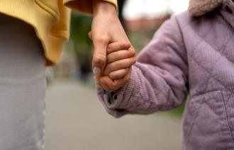 Kind und erwachsene Person Hand in Hand