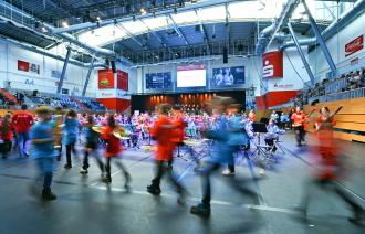 Viele Kinder mit Musikinstrumenten laufen so schnell in die große MBS Arena, dass sie nur unscharf zu erkennen sind