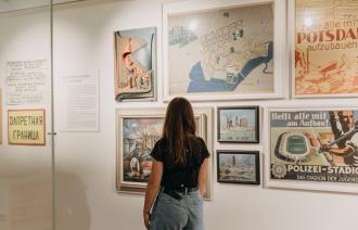 Eine Frau läuft durch die Stadtgeschichtliche Ausstellung im Potsdam Museum mit dem Rücken zur Kamera.