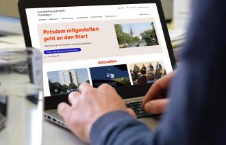 Notebook mit der Startseite von mitgestalten.potsdam.de, an dem eine Person arbeitet.