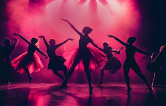 Zu sehen ist eine Reihe von Tänzerinnen in rotem Scheinwerferlicht