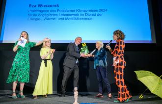 Der Beigeordnete für Stadtentwicklung, Bauen, Wirtschaft und Umwelt, Bernd Rubelt, übergibt den Potsdamer Klimapreise an Eva Wieczorek