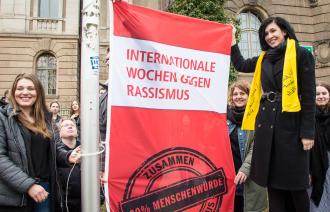 Die Beigeordnete Noosha Aubel hisst Flagge der Internationalen Wochen gegen Rassismus
