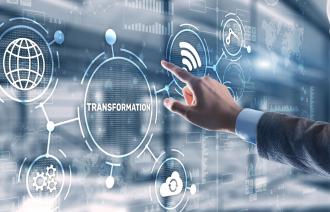 Das Bild zeigt einen Touchscreen mit Symbolen für W-Lan, Cloud und das Internet sowie den Schriftzug Transformation. Eine Hand berührt den Touchscreen.