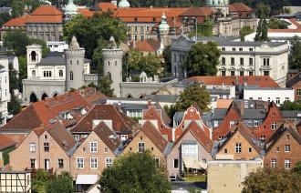 Das Foto zeigt im Vordergrund Dächer des Holländischen Viertels, das Nauener Tor und das Potsdamer Rathaus.