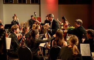 Der Oberbürgermeister Mike Schubert und die Direktorin der Städtischen Musikschule Heike Lupuleak überreichen Rosen im Jugendsinfonieorchester.