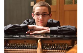 Ein junger Pianist schaut über die Saiten seines Konzertflügels