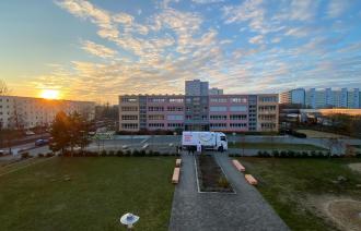 Der weite Campus in der Abendsonne mit dramatischem Himmel - der Jazztruck sieht fast wie ein Spielzeug aus