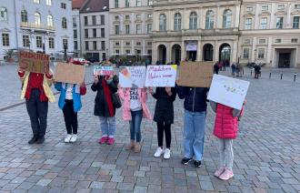 6 Mädchen halten selbstgeschriebene Bilder Mädchenforderungen hoch