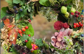 Herbstkranz aus grünen Blättern, roten Beeren, Zapfen, Hopfen und Hortensien, in Händen gehalten., Foto: Nicole Riekeles, Lizenz: Nicole Riekeles