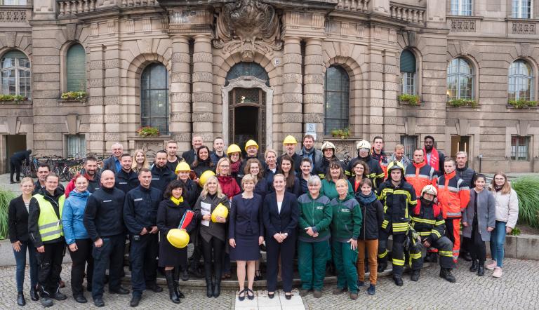 Mehrere Beschäftigte der Landeshauptstadt Potsdam stehen vor dem Rathaus.
