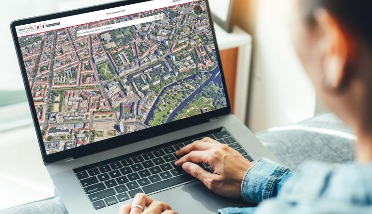Eine Person schaut sich auf einem Laptop den "Wirtschaftsatlas Berlin" an.