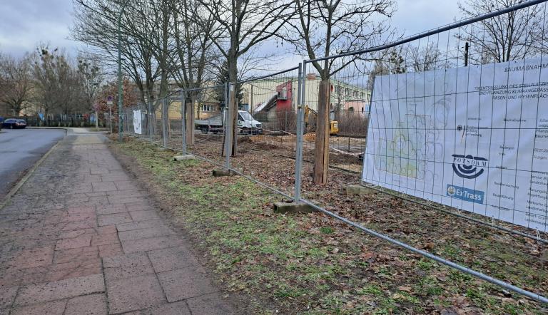 An einem Bauzaun hängt ein erklärende Plakat zu den Maßnahmen.