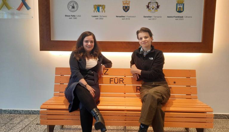 Claudia Sprengel und Bianca Strzeja sitzen auf der "Bank für Respekt" im Foyer der Edisonallee.. 