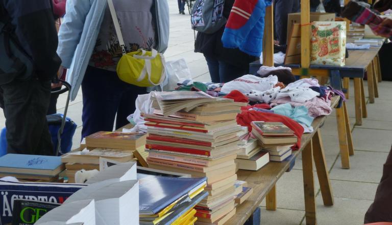 Gegenstände, bspw. Bücher, Vasen, Kleidung, an einem Stand des Geben- und Nehmen-Markts