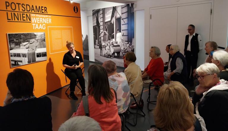 Ältere Menschen sitzen und hören bei der Veranstaltung Silver Salon zu.