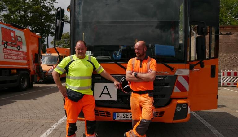 Heiko Grützmacher (links) und Marcel König (rechts) vor ihrem Entsorgungsfahrzeug nach fertiggestellter Tour