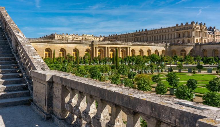 Schloss Versaille in Frankreich, man schaut von einer Erhöhung über den Garten zum Schloss.