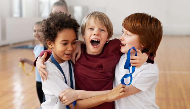 Drei Jungen in einer Turnhalle, die zusammen spielen.