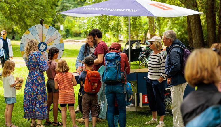 Menschen am Stand der Tourist-Information