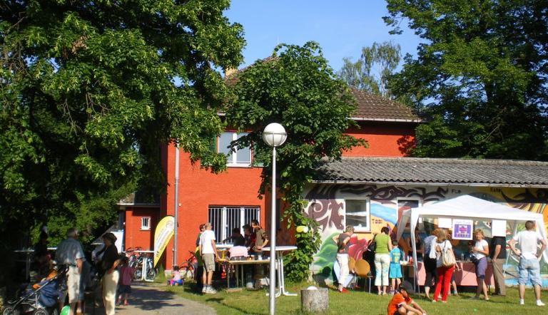 Das Groß Glienicker Begegnungshaus bei einem Fest, an dem viele Menschen vor dem Haus sind.