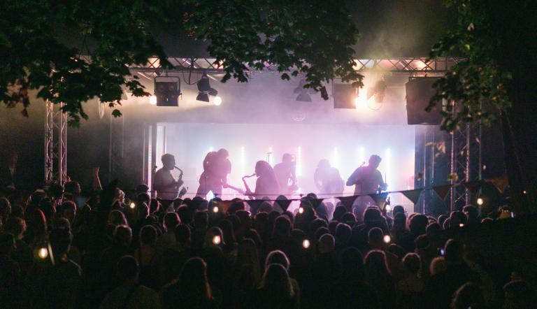 Eine Band auf der Bühne im Lindenpark spielt vor einer breiten Masse.