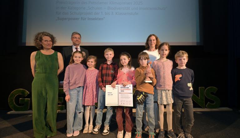 Schülerinnen, Schüler und Lehrerin der Silberdelfine der Evangelischen Grundschule mit OBM Schubert, Moderatorin Julia Vismann