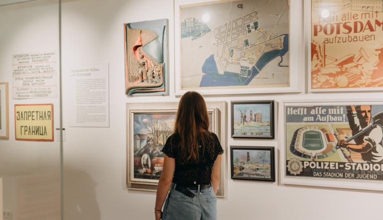 Eine Frau läuft durch die Stadtgeschichtliche Ausstellung im Potsdam Museum mit dem Rücken zur Kamera.