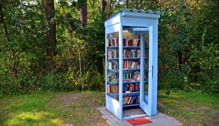Eine öffentliche Telefonzelle, die zum bücherschrank umgebaut wurde.