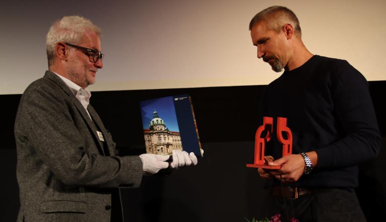 Dieter Jetschmanegg übergibt einen der von der Künstlerin Susanne Sprecht gestalteten Wanderpokal für den Integrationspreis