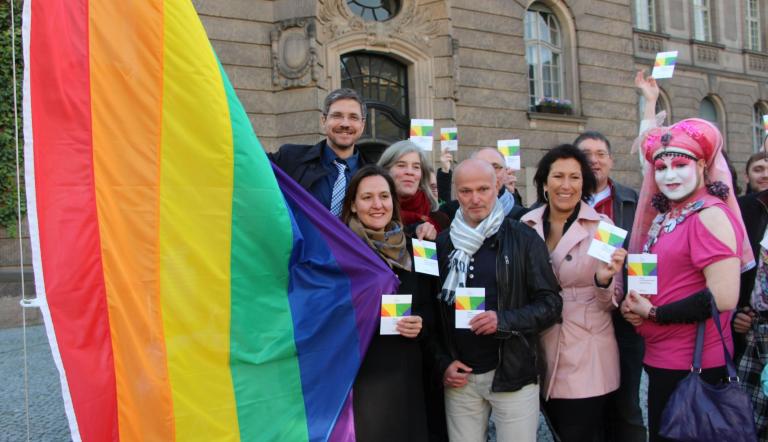 Mike Schubert hat gemeinsam mit (v.l.n.r. Dr. Manja Schüle, Marie-Luise von Halem, Volkmar Schöneburg, Kristy Augustin und anderen) die Regenbogenflagge vor dem Rathaus Potsdam gehisst