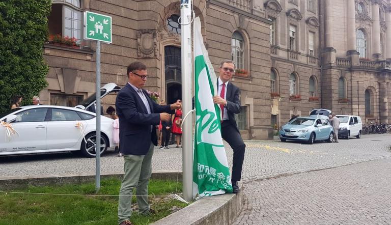 Mayors for Peace: Bürgermeister Burkhard Exner und Uwe Fröhlich (l.) hissen die Flagge vor dem Rathaus.