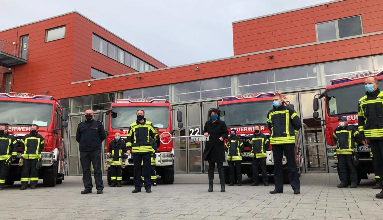 Die Beigeordnete für Ordnung, Sicherheit, Soziales und Gesundheit, Brigitte Meier, und Feuerwehr-Chef Ralf Krawinkel übergeben die Schlüssel für die neuen Fahrzeuge an Mitglieder der Freiwilligen Feuerwehren.
