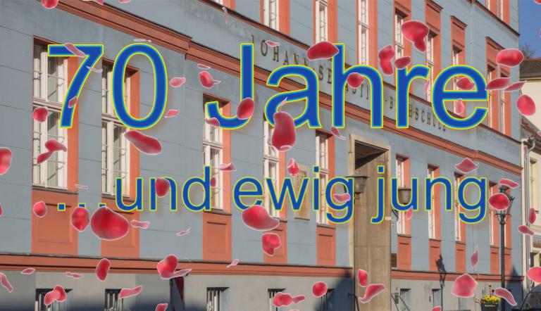 Vor dem schönen Gebäude der Musikschule regnet es Rosenblätter