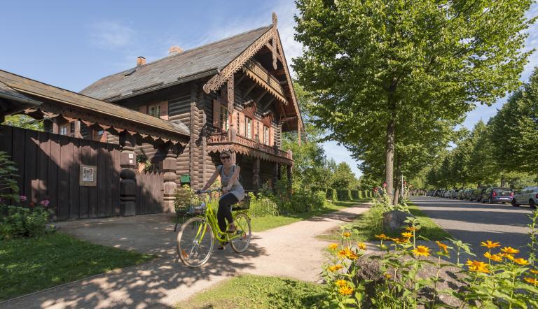 Eine Fahrradfahrerin vor der Russischen Kolonie Alexandrowka.