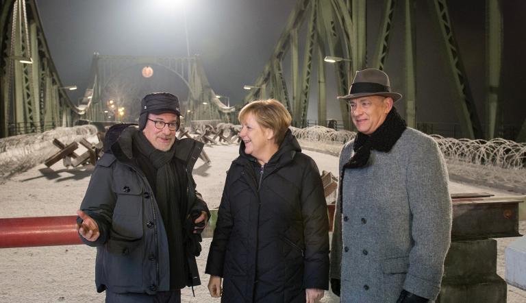 Angela Merkel besucht die Dreharbeiten von BRIDGE OF SPIES des Hollywood-Regisseurs Steven Spielberg (li.) mit Tom Hanks (re.) auf der Glienicker Brücke. Angela Merkel besucht die Dreharbeiten von BRIDGE OF SPIES des Hollywood-Regisseurs Steven Spielberg (li.) mit Tom Hanks (re.) auf der Glienicker Brücke.