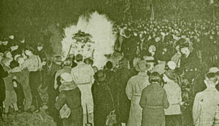 Das historische Pressefoto zeigt eine große Menschenmenge in Babelsberg, die um ein Feuer steht: Schaulustige beobachten die Bücherverbrennung.