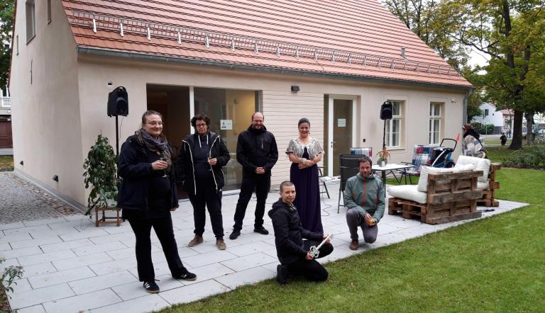 Gregor Jekel, Fachbereich Wohnen, Arbeit und Integration, der Vorstand Interlog e.V. und die Sängerin Kristina Gordadze bei der Eröffnung des Nachbar*innenschafts- und Begegnungshaus „Heidehaus“ in Potsdam Babelsberg.