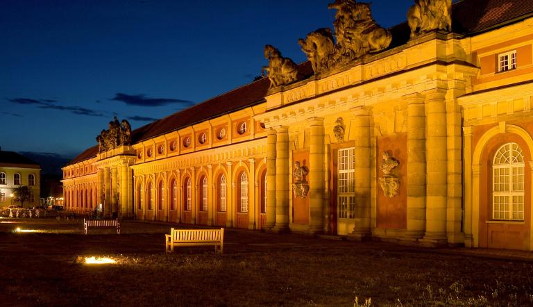 Das Filmmuseum Potsdam wird in der Abenddämmerung beleuchtet.