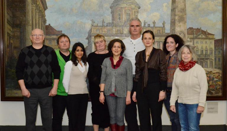Mitglieder Migrantenbeirat 2016 Vor dem Gemälde des Alten Marktes im Potsdamer Rathaus stehen neun Mitglieder des Migrantenbeirates, sechs Frauen und drei Männer.