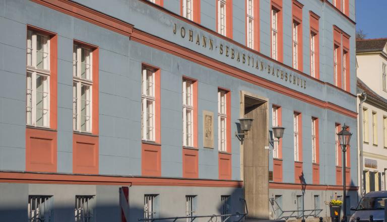 Die Musikschule hat ihren Sitz in der Jägerstraße. Auf der blau-roten Fassade ist der Schriftzug „Johann-Sebastian-Bach-Schule“ zu lesen. Links neben der Tür ist ein Portrait des Komponisten zu sehen.