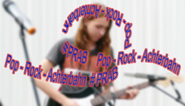 Projekt: Pop-Rock-Achterbahn (Foto J.Pfeuffer; DIe Worte Pop-Rock-Achterbahn #PRAB reihen und ringeln sich wie eine Achterbahn - im Hintergrund ist ein Gitarrist zu sehen