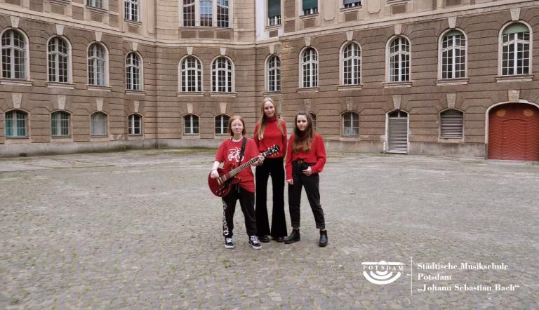 3 jugendliche Mädchen stehen in einem großen Innenhof des Rathaus Potsdam - sie sind die Band "Spiritual Section"